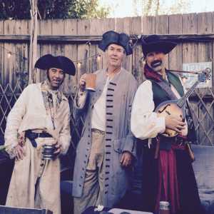 three guys drinking by  fence